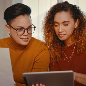 Two women discuss their finances with a Patelco Home Loan Consultant.